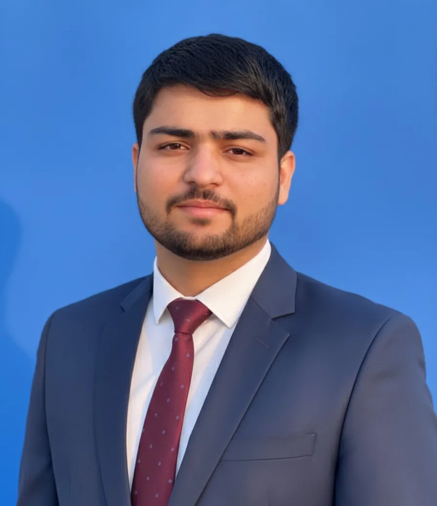 Portrait of Haseeb Sagheer in a navy suit against a blue background